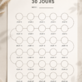 Un tracker d'économies de 30 jours sur un bureau, avec un stylo et des pièces de monnaie.